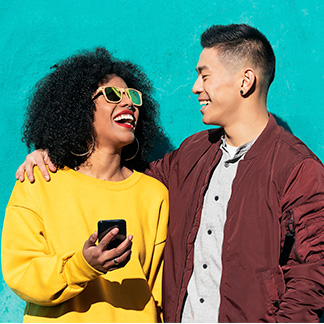 Woman holding phone looking next to smiling man