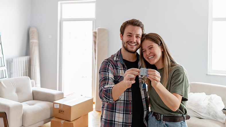 A happy couple holding keys to their new home.
