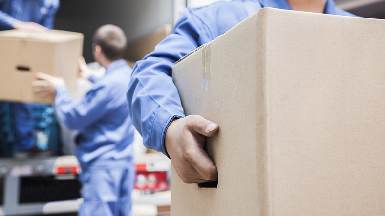 A group of men moving boxes off a truck