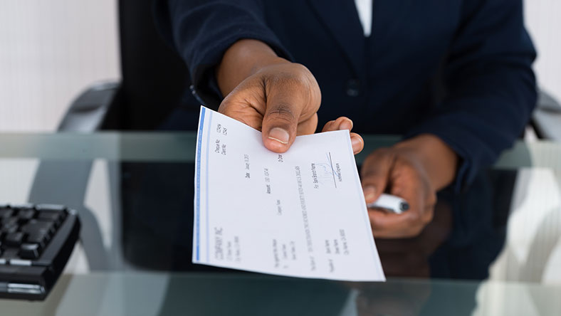 Man handing over a check to you