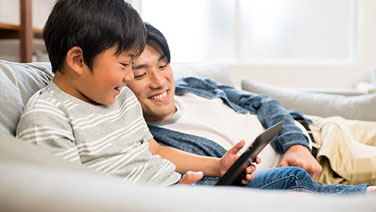 Young son holding calculator with brother