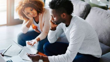 Couple looking frustrated at bills