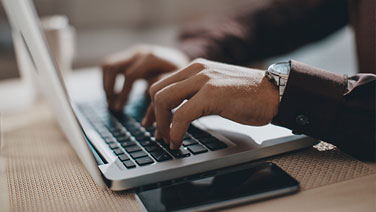 hands typing on laptop