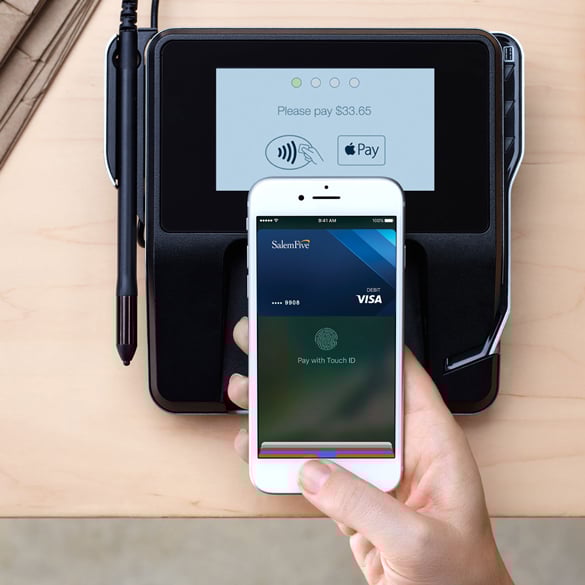 Easily Add Your Salem Five Debit Card To Your Digital Wallet Hand holding smartphone making a payment
