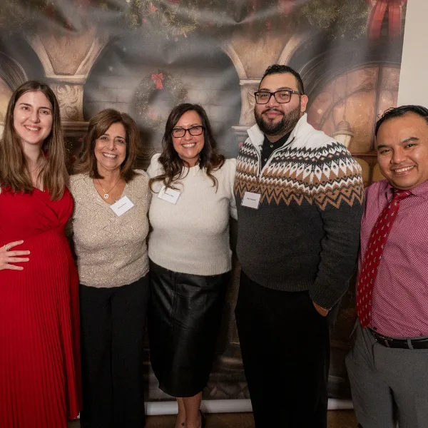 Salem Five employees posing together at a holiday-themed event with festive backdrop.