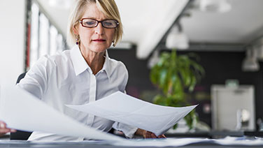 Woman shuffling papers at her desk