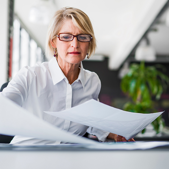 Woman shuffling papers at work desk