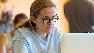 Woman wearing glasses working on laptop