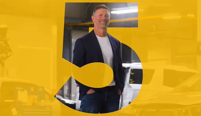 Person standing in auto body setting with a large stylized number 5 overlay.