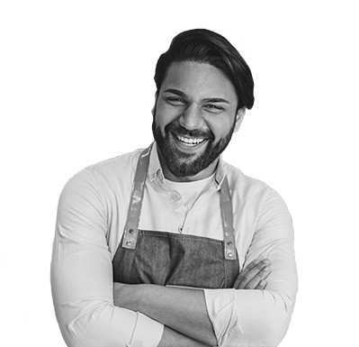 Man wearing apron with arms crossed and smiling